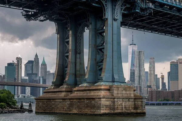 ニューヨークのブルックリン ブリッジ ベースのローアングル ショット 背景には街並みが描かれている — ストック写真