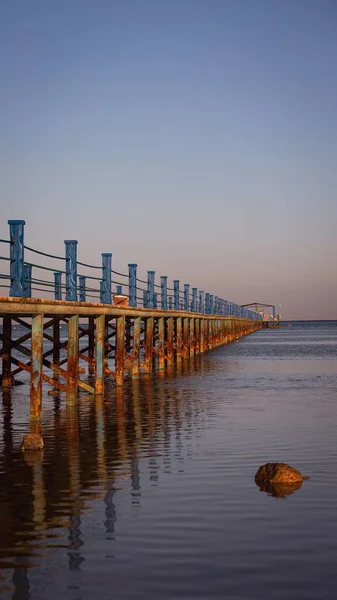 Arka Planda Pembe Günbatımı Olan Sakin Deniz Suları Üzerinde Bir — Stok fotoğraf