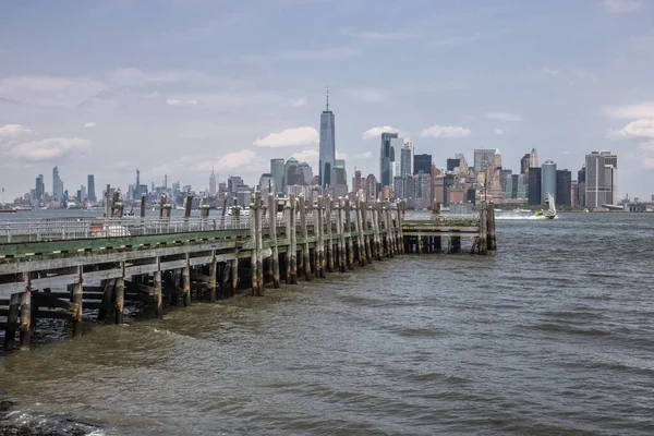 东河中的一个木制码头 背景是纽约的城市景观 蓝天上有云彩 — 图库照片