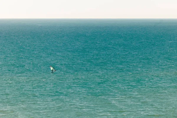 カナリア諸島での休暇中に静かなターコイズブルーの海でウィンドサーフィンをする人 — ストック写真