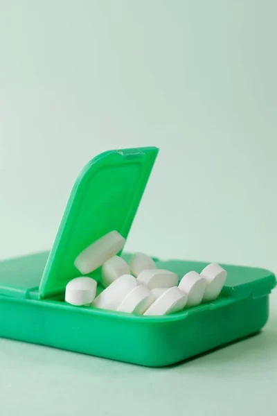 Eine Vertikale Nahaufnahme Weißer Pillen Einer Grünen Pillbox Auf Weißem — Stockfoto