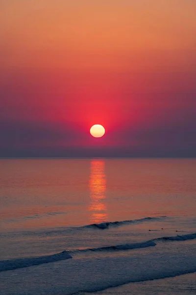Vertikální Záběr Úchvatně Rudého Západu Slunce Nad Mořem Večerních Hodinách — Stock fotografie