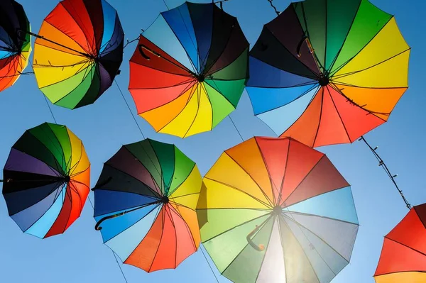 Vacker Bild Regnbåge Paraplyer Hängande Från Linjerna Den Blå Himlen — Stockfoto
