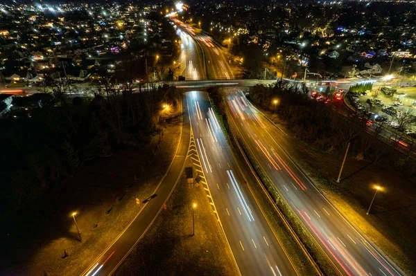夜间照明道路的鸟瞰图 长期暴露在车灯下 背景为城市景观 — 图库照片