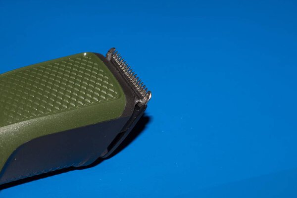 A closeup shot of a hair trimmer isolated on the blue background