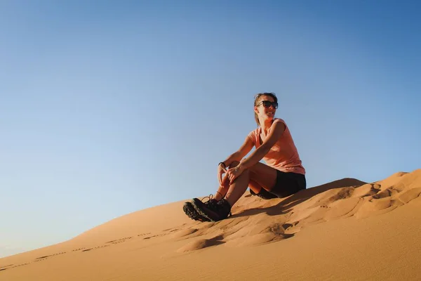 stock image A Caucasian woman sitting on the sand in a desert