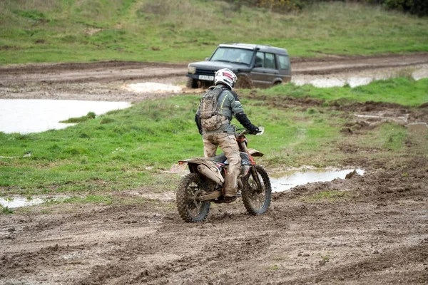 昼間は泥だらけの地形を走るオフロードバイク — ストック写真