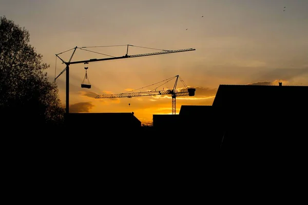 stock image A scenic sunset over the buildings and silhouettes of tower cranes