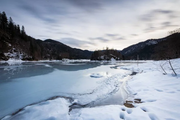 Ein Feld Und Ein Zugefrorener Fluss Bedeckt Mit Schnee Und — Stockfoto