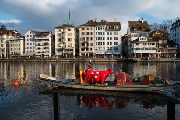 苏黎世的Limmat河与一条漂浮的船 一头红色的奶牛和沿河的古老建筑的横向视图 — 图库照片
