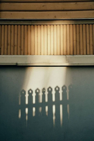 一道垂直的墙壁 入口栅栏在阳光的阴影下反射出来 — 图库照片