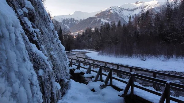 Tiro Close Uma Ponte Rio Montanhas Cobertas Neve Dia Frio — Fotografia de Stock