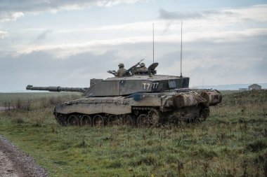 Askeri tanklar bir tarlada hareket ediyor.