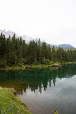 İtalya 'da arka planda Dolomitler olan bir gölün dikey çekimi
