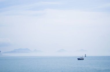 Sisli bir deniz manzarasına karşı bir tekne