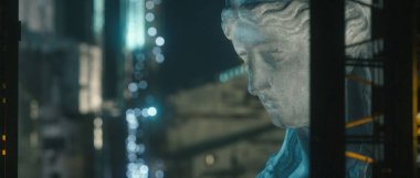 Bokeh 'li bir Roma heykelinin kafasının sığ odağı geceleri binaları aydınlatıyor.