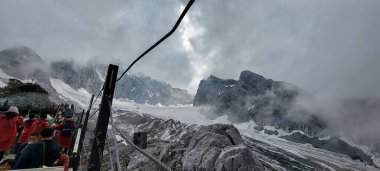 Lijiang Çin 'deki Yeşim Ejder dağının manzaralı bir görüntüsü bulutlarla kaplı.