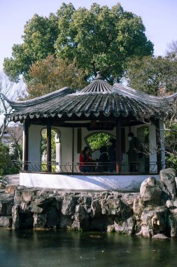 Suzhou 'nun Klasik Bahçeleri' ndeki bir pavyonda insanların dikey görüntüsü..