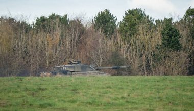 Askeri tanklar bir tarlada hareket ediyor.