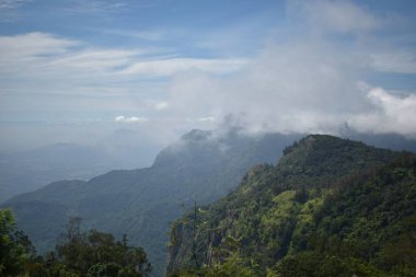 Bulutlu gökyüzü huzurlu yeşil dağların üzerinde