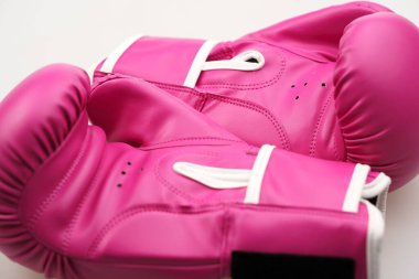 Beyaz arka planda izole edilmiş pembe boks eldivenlerinin yakın plan çekimi.