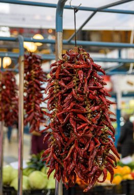 Piyasada kurutulmuş kırmızı biberli bir ipin dikey yakın çekimi.