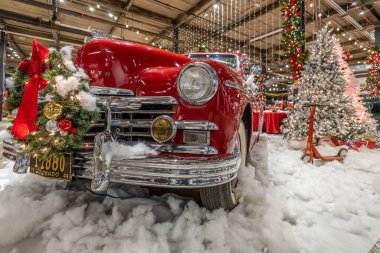 Müzede sahte kar ve Noel süslemeleri olan klasik kırmızı bir araba.