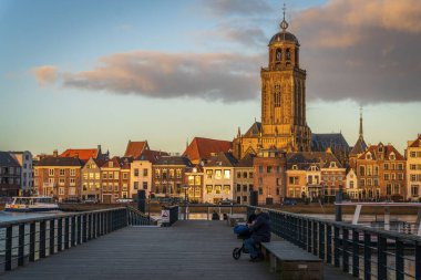 Hollanda 'daki Saint Lebuinus Kilisesi ile Deventer siluetine karşı bir feribot iskelesi.