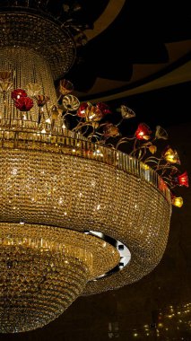 Bir binanın koridorundaki avizenin ve renkli lambaların dikey yakın çekimi.