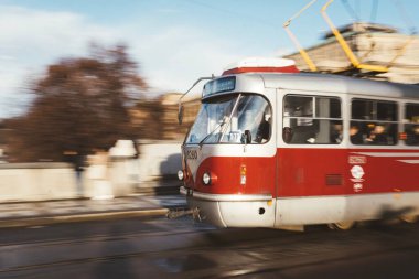 Çek Cumhuriyeti 'nin Prag kentindeki Manes Köprüsü' nde mavi gökyüzü altında eski bir tramvayın uzun süreli görüntüsü.