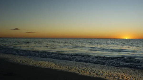 지평선에는 언덕으로 둘러싸인 모래사장 황금빛 하늘이 펼쳐져 배경에 완벽하다 — 스톡 사진