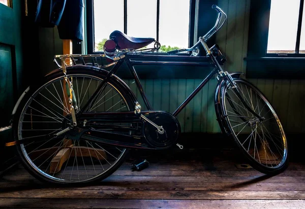 木製の床に巨大な車輪を持つ家の中の現代的な自転車 — ストック写真