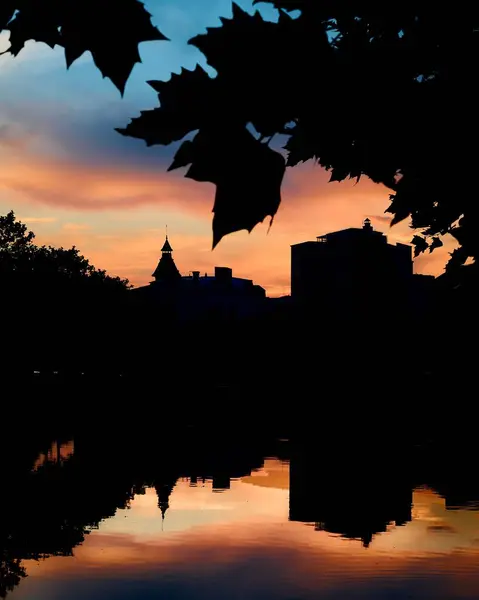 Sjö Vid Solnedgången Som Reflekterar Stadens Byggnader Och Den Molniga — Stockfoto