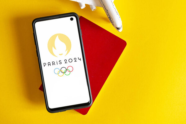 A red notebook with a yellow background and a flat lay of a phone with the Paris 2024 and Olympics logos on it