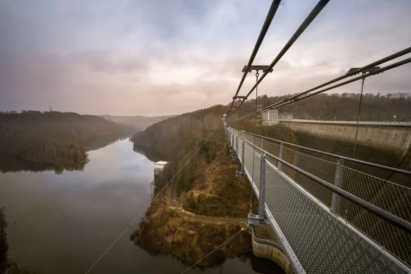 曇った空の下で谷の上に非常に長い吊り橋 — ストック写真
