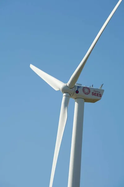 Vertikální Záběr Větrné Turbíny Kopci Modrým Pozadím Oblohy — Stock fotografie