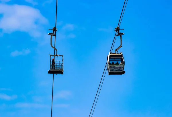 一个低角度的缆车 里面的人从蓝天下的高处观看风景 — 图库照片