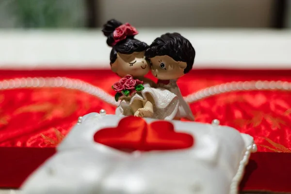Selective Focus Tiny Figurines Groom Bride Red Surface Blurry Background — Stock Photo, Image