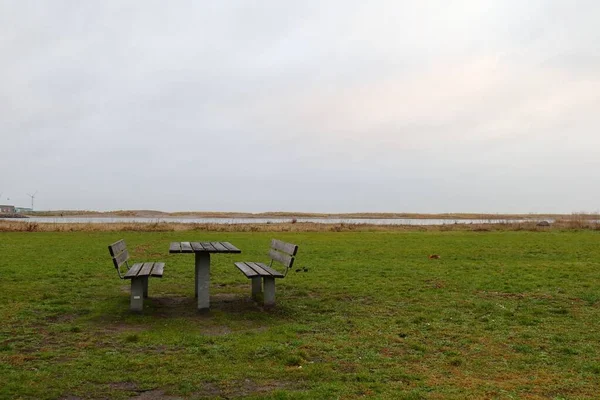 湖の近くの自然の中にある木製のテーブルとベンチ — ストック写真