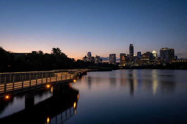 A beautiful view of TX skyline at sunset from the boardwalk around Town Lake in Austin