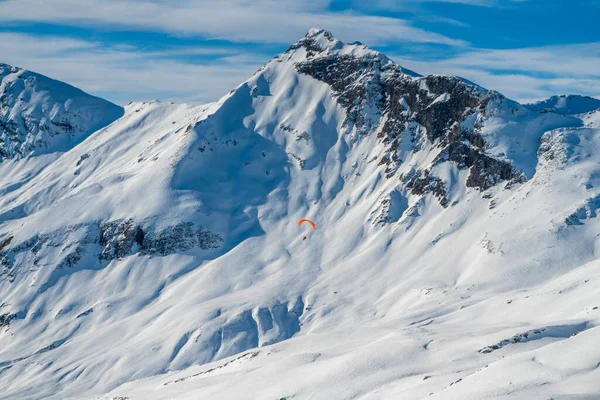 Een Paraglider Met Een Rotsachtige Berg Bedekt Met Sneeuw Achtergrond — Stockfoto