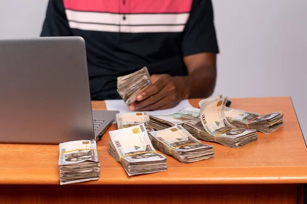ノートパソコンで大金を稼ぐアフリカのビジネスマン — ストック写真