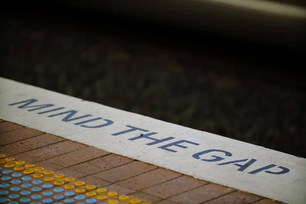 stock image A text warning MIND THE GAP on stone platform on train or metro station