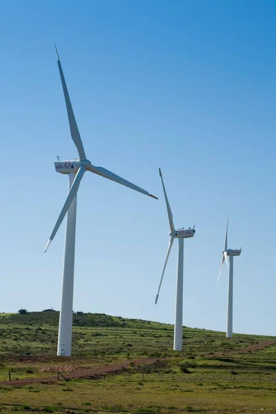 Vertikální Záběr Větrné Turbíny Kopci Modrým Pozadím Oblohy — Stock fotografie