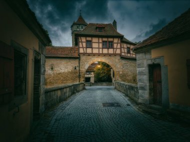 Rothenburg ob der Tauber Town, Altstadt, Bayern, Almanya 'da bulutlu gökyüzü altında eski evleri olan dar bir ara sokak.