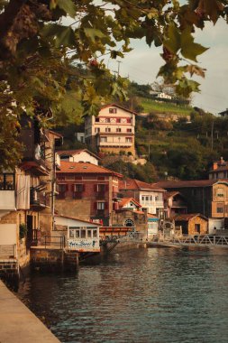 Günbatımında sahildeki eski, tipik evler ve kafeler, dikey