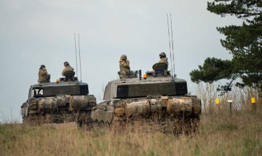 Askeri tanklar bir tarlada hareket ediyor.