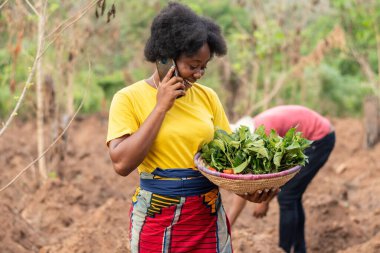 Kadın Afrikalı çiftçi bir telefon görüşmesi yapıyor.
