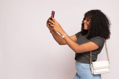 Güzel siyah bayan, telefonuna gülümsüyor.