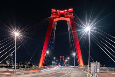 Rotterdam 'daki aydınlatılmış Willems Köprüsü gece geç saatlerde sokak ışıklarının yanında ele geçirildi.